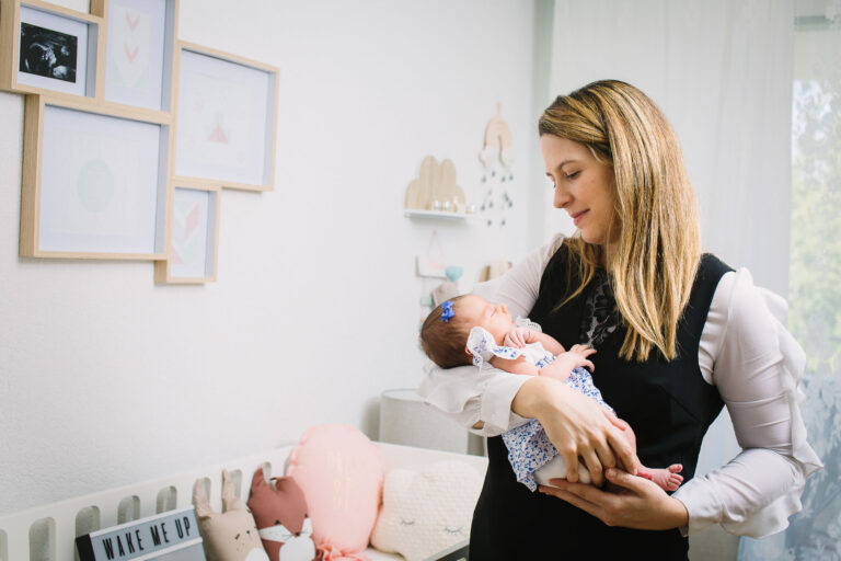 Mum holds her baby daughter in the nursery
