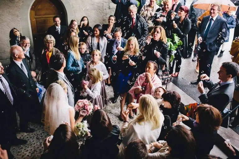 Wedding couple exit the church to bubbles.