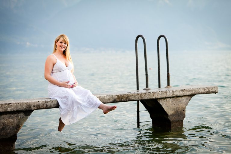 Maternity photo sitting by the lake in the summer