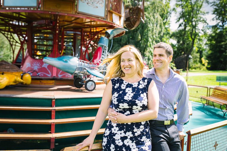 Engaged couple by a carousel