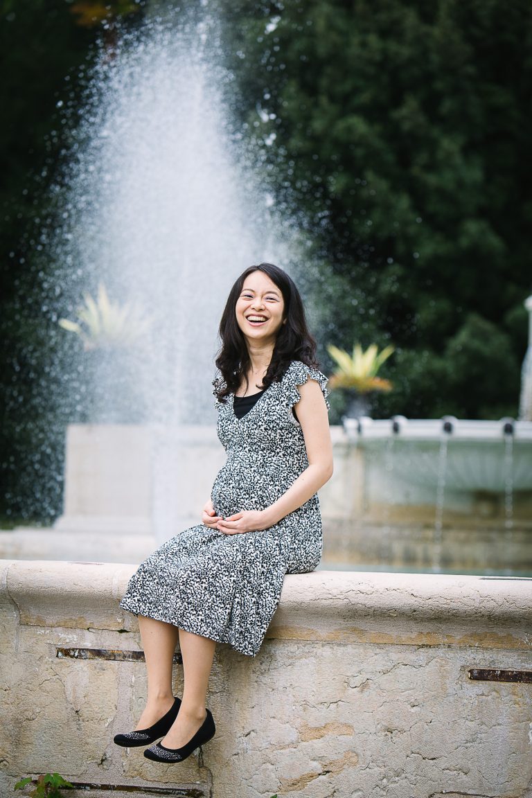 Pregnant woman by a fountain.