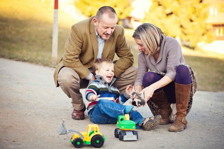 Little boy and his parents with trucks
